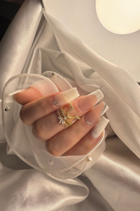 Un gros plan des ongles d'une personne avec une bague dessus.