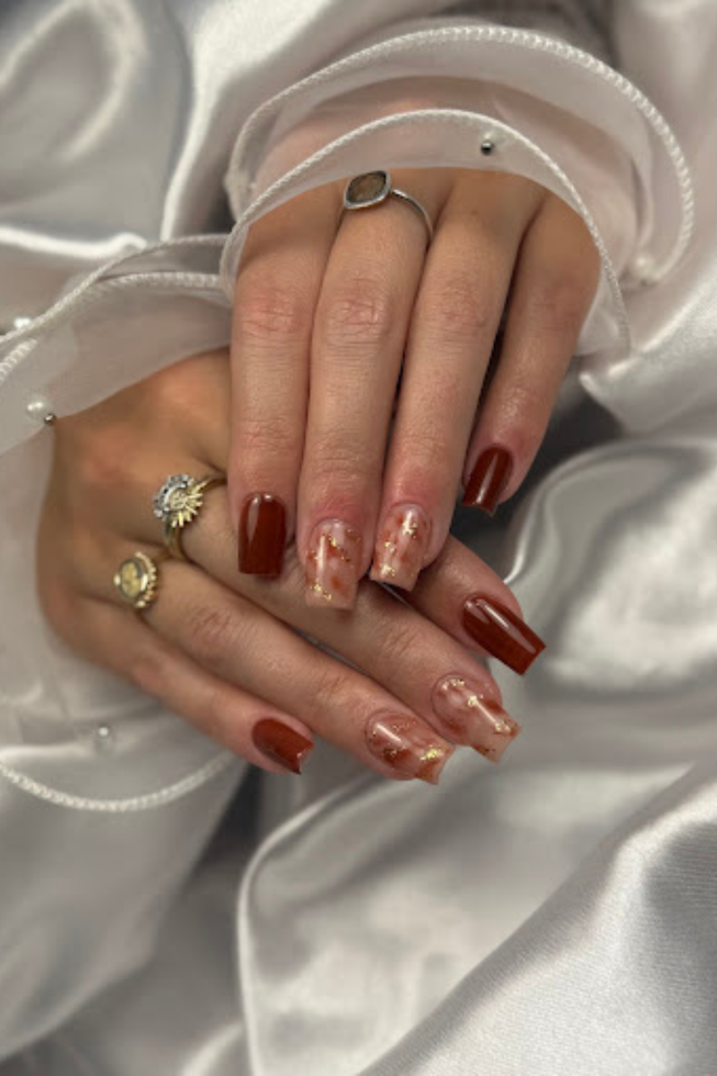 Un gros plan des mains d'une femme avec des ongles rouges et des bagues.