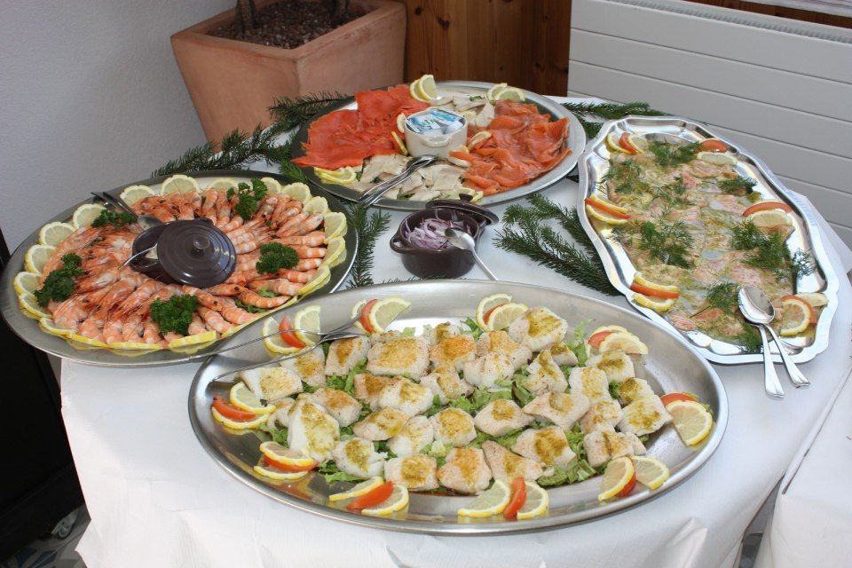 Une table garnie d'assiettes de nourriture comprenant des crevettes et des citrons