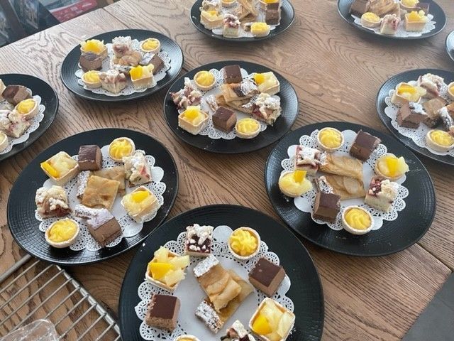 Une table surmontée d'assiettes noires remplies de différents types de desserts.