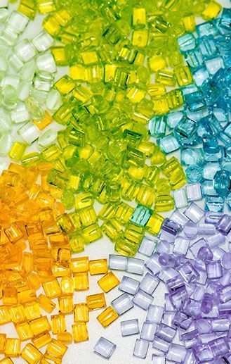 Bolitas de plástico de colores del arco iris dispuestas en un degradado vibrante, mostrando varios matices.