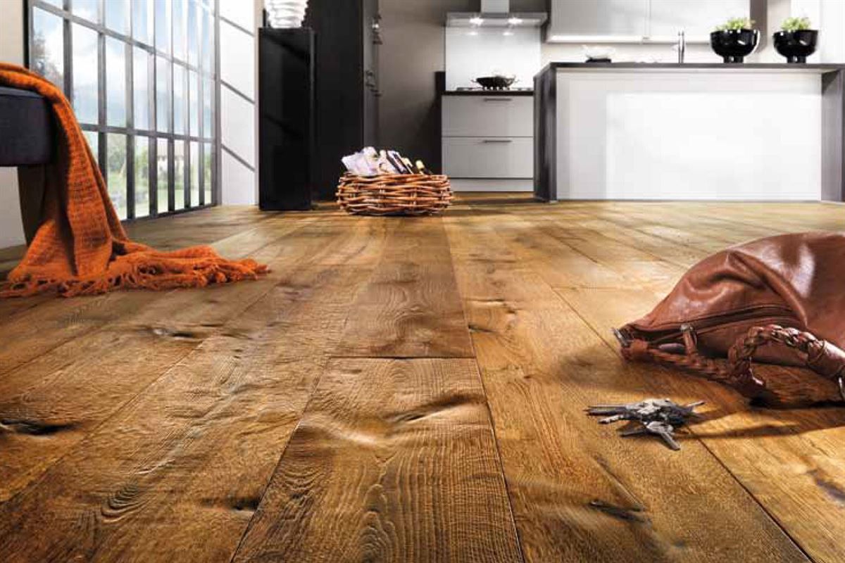 Ein Holzboden in einer Küche mit einer Handtasche und Schlüsseln darauf.