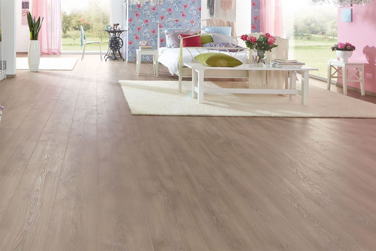 Ein Wohnzimmer mit Holzboden und einem Bett.