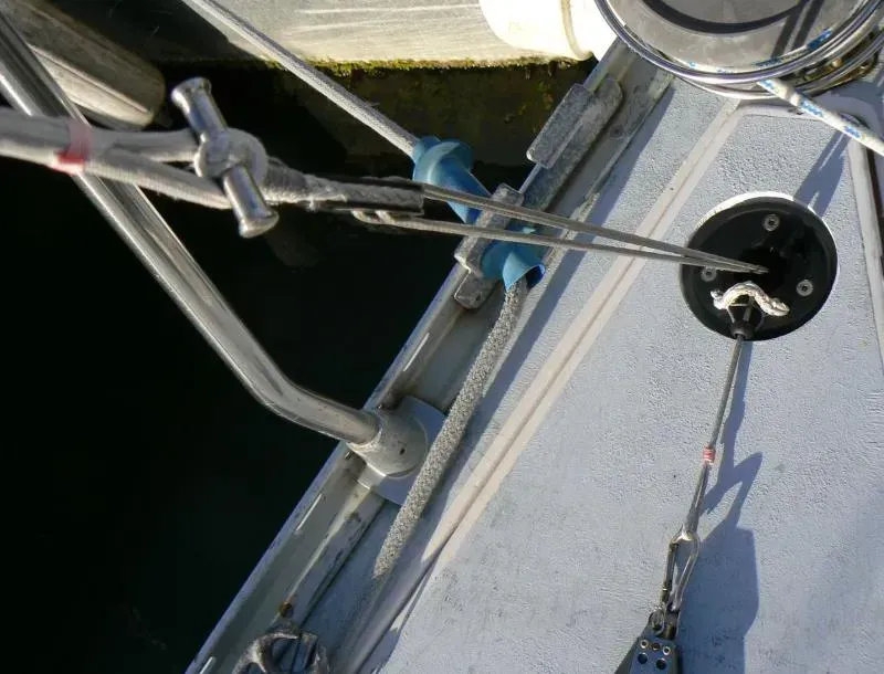 Gros plan sur le pont d'un voilier montrant un chariot d'écoute de foc, une ligne et une poulie de renvoi montée sur le pont avec des pièces en acier inoxydable.
