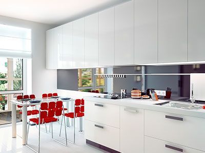 Cocina blanca moderna con sillas rojas y una mesa.