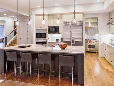 Cocina moderna con isla de asientos, electrodomésticos de acero inoxidable