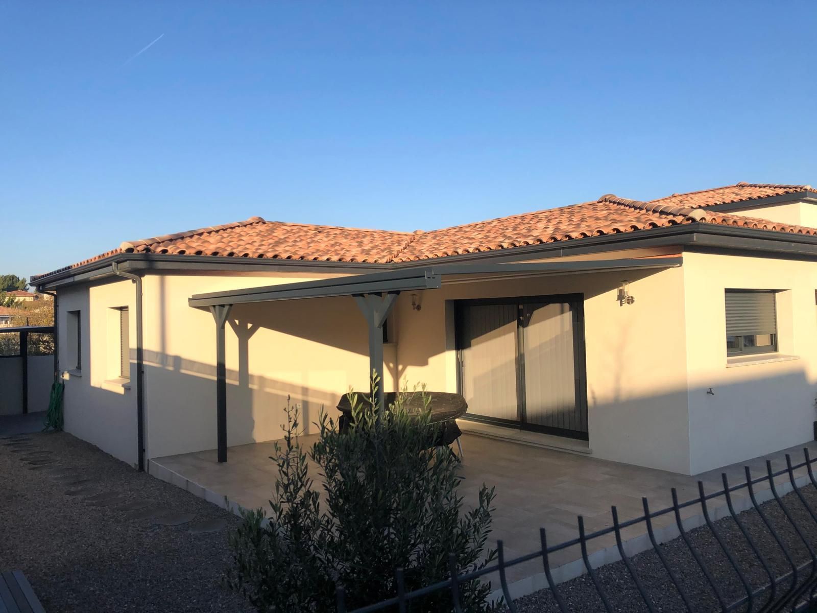 Pergola protégeant une terrasse, vue sur façade de maison