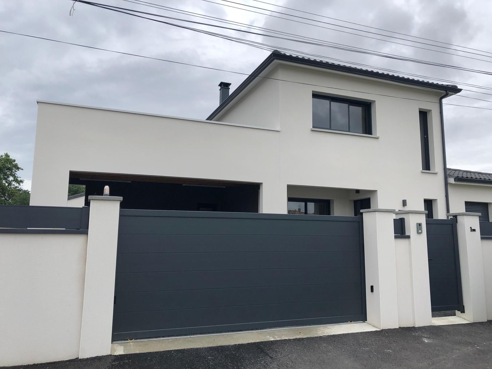 Portail gris, maison à étages