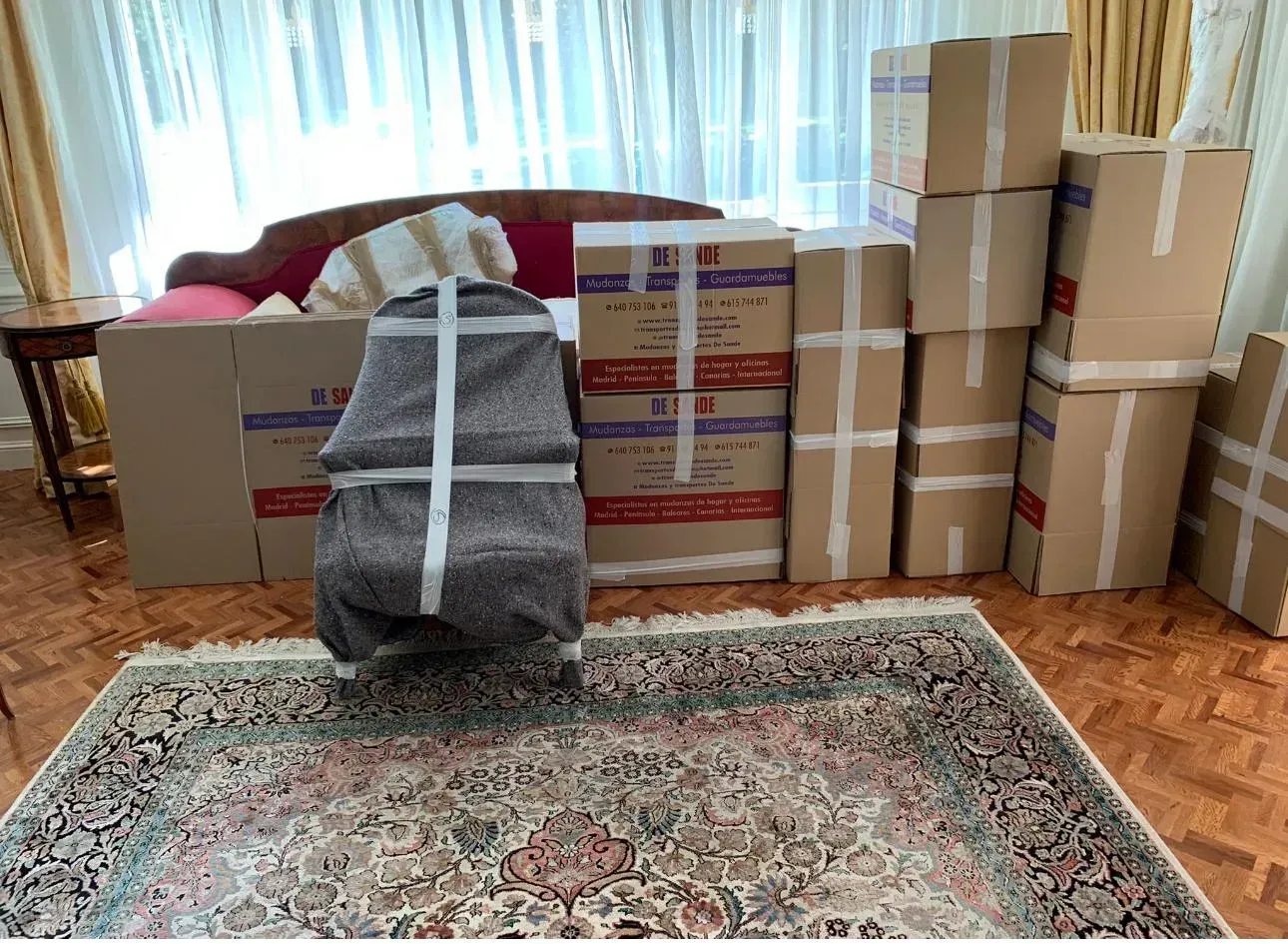 Cajas y muebles envueltos en plástico, listos para ser trasladados.