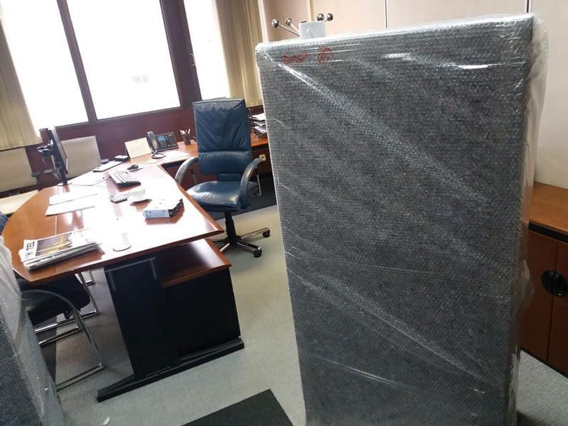 Altavoz envuelto en una funda en la oficina, junto a un escritorio con una silla de cuero.