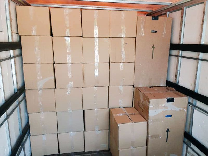 Cajas apiladas dentro de un camión, listas para su transporte.