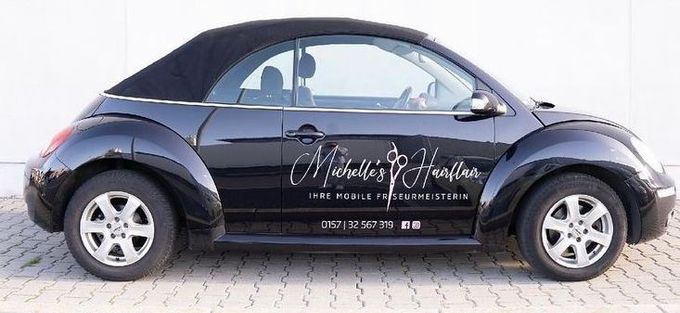 Ein schwarzes Auto mit dem Wort Michelle auf der Seite