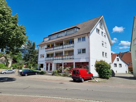 Ein weißes Gebäude mit einem davor geparkten roten Lieferwagen