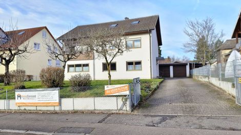 Ein weißes Gebäude mit einem davor geparkten roten Lieferwagen