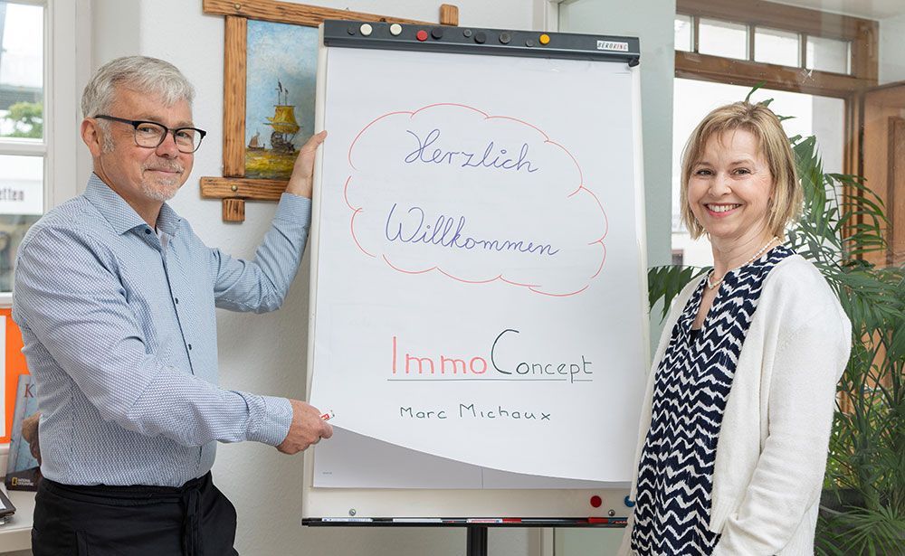 Ein Mann und eine Frau stehen vor einem Whiteboard.