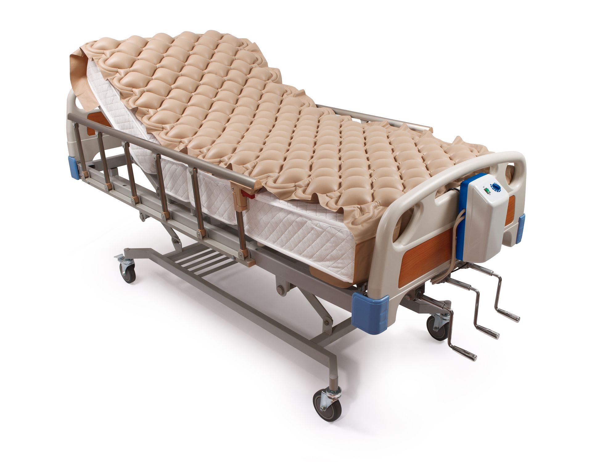 Lit d'hôpital avec matelas beige à décharge de pression, barrières latérales et roulettes.
