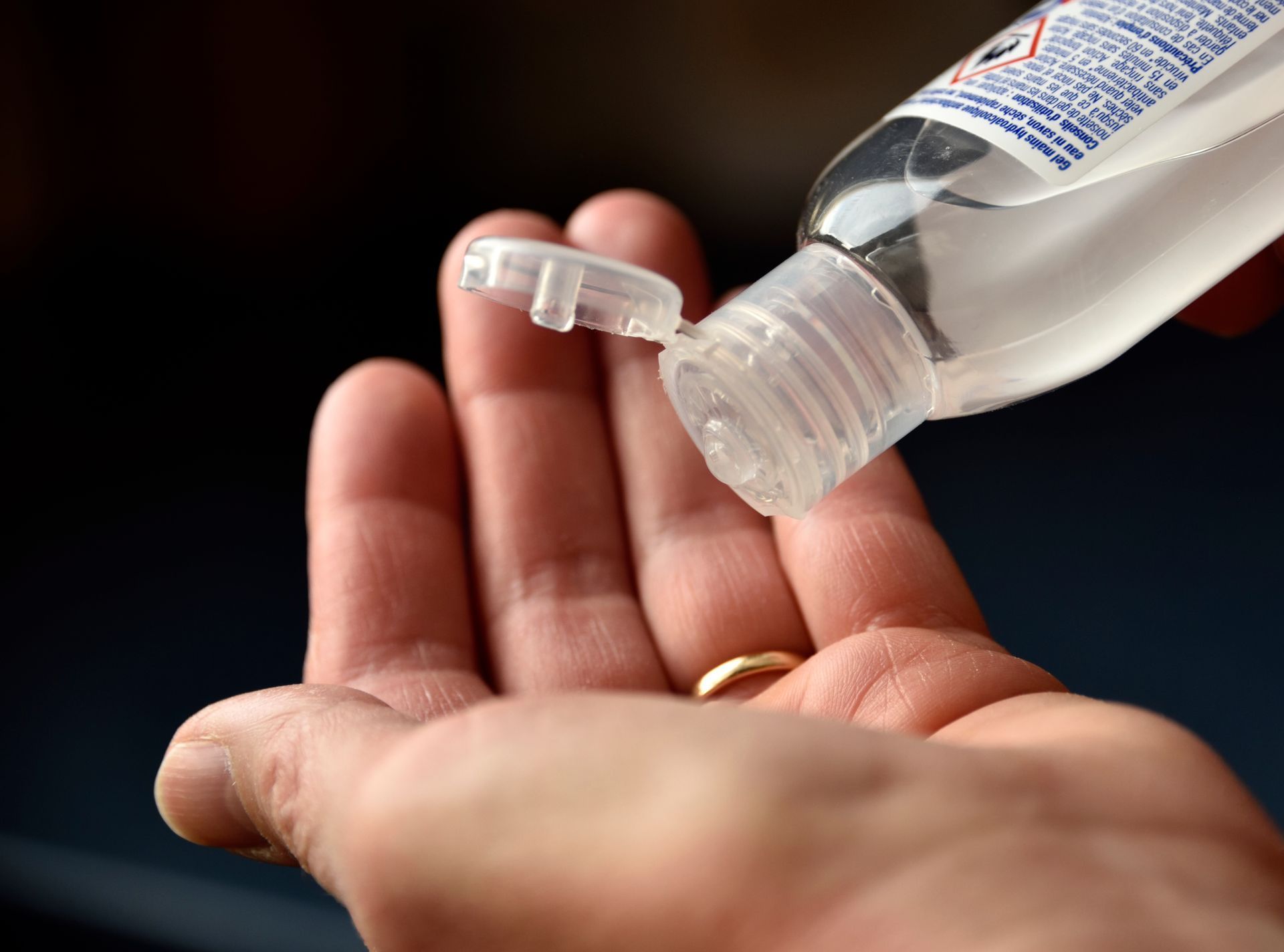 Une personne verse du gel hydroalcoolique dans sa main.