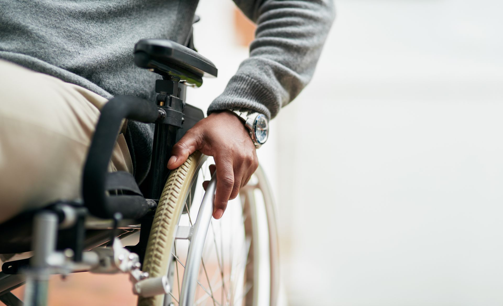 Une personne assise dans un fauteuil roulant dans un environnement intérieur lumineux.
