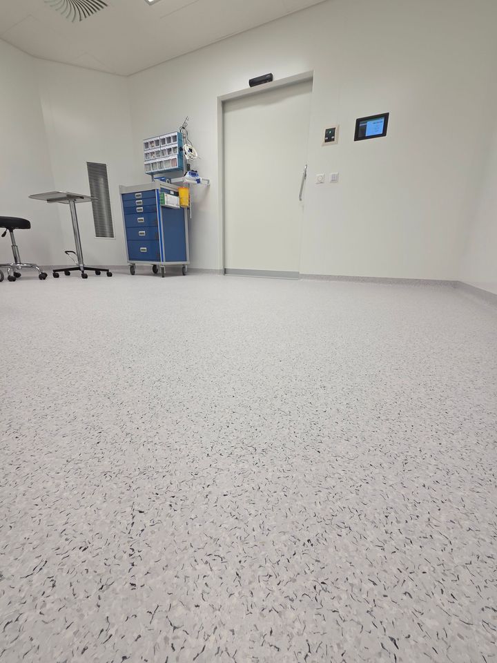 Un salon avec un canapé vert et un tapis rouge.