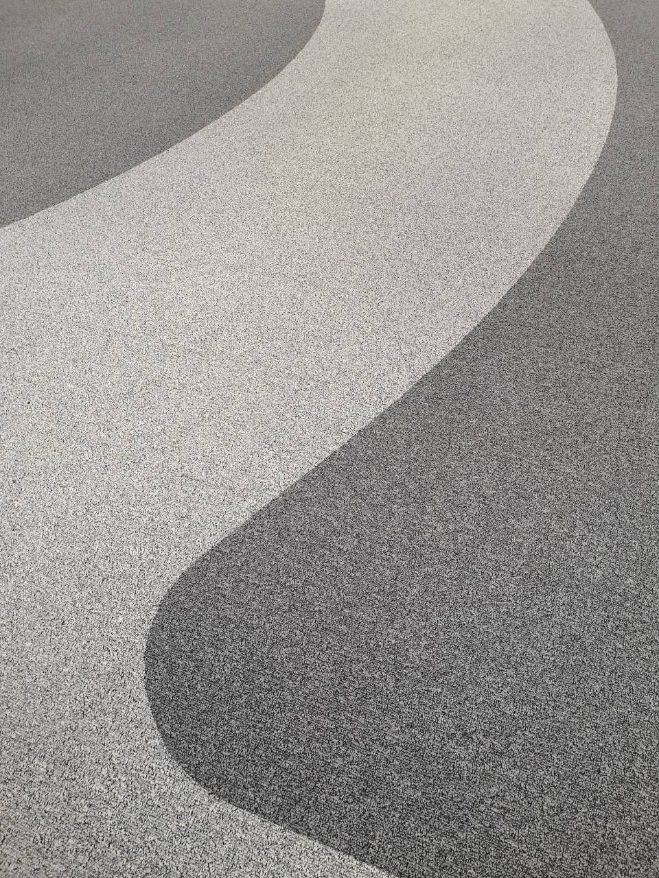 Un gros plan d'un tapis gris et blanc avec un motif tourbillonnant.