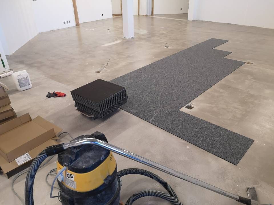 Un aspirateur est posé sur le sol dans une pièce vide.