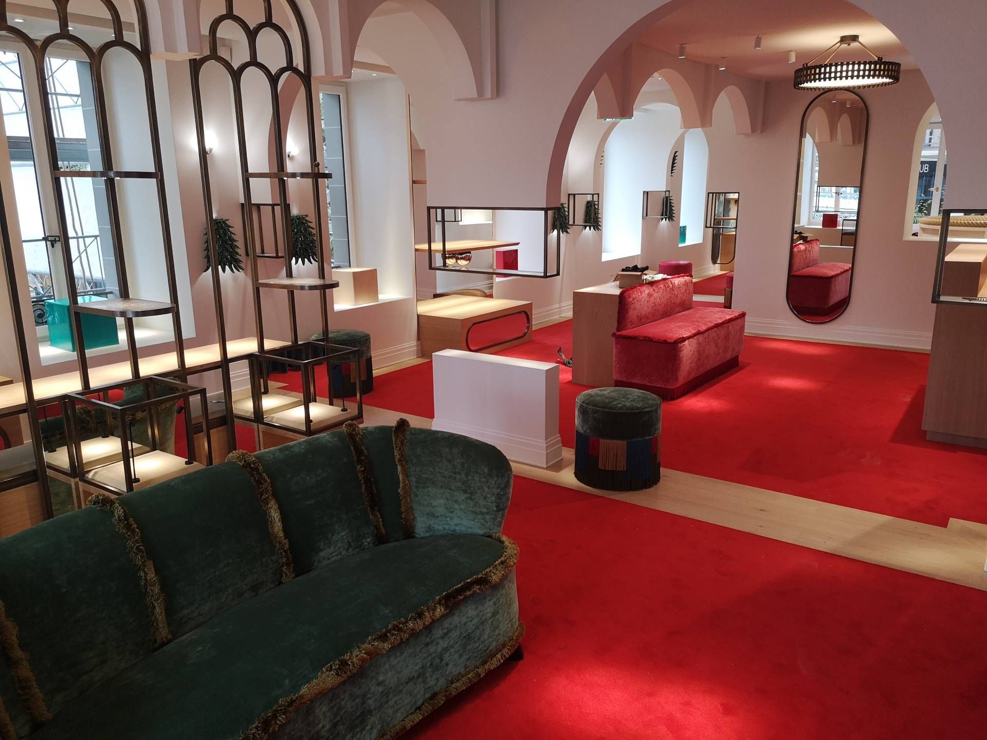 Un salon avec un canapé vert et un tapis rouge.