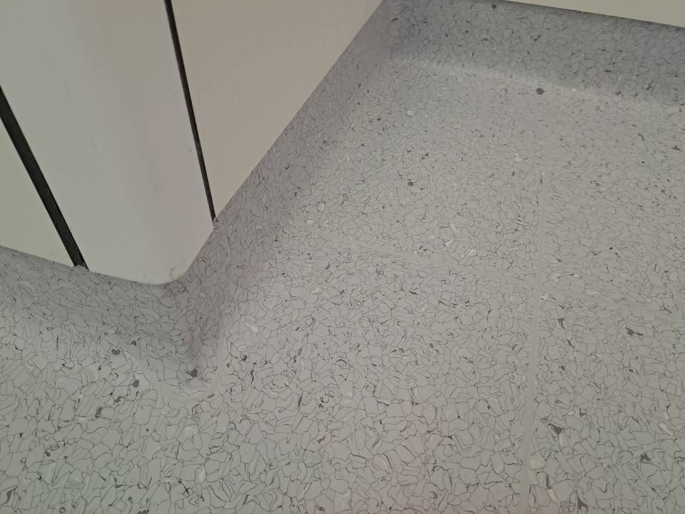 Un gros plan d'un sol blanc avec une armoire blanche en arrière-plan.