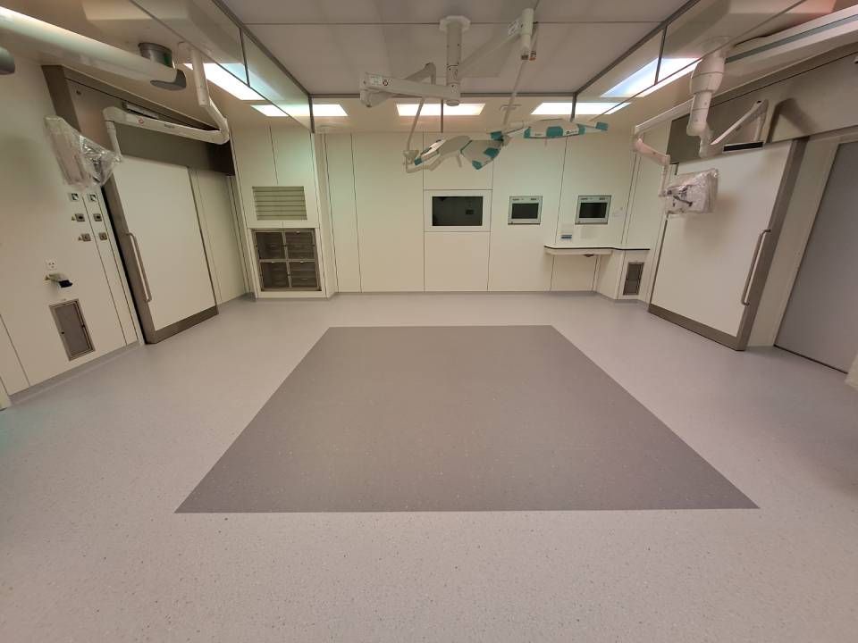 Une salle d'opération vide avec un grand tapis sur le sol