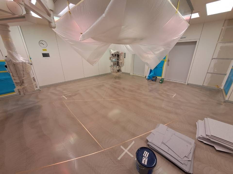 Une pièce avec beaucoup de plastique recouvrant le plafond et un seau sur le sol.