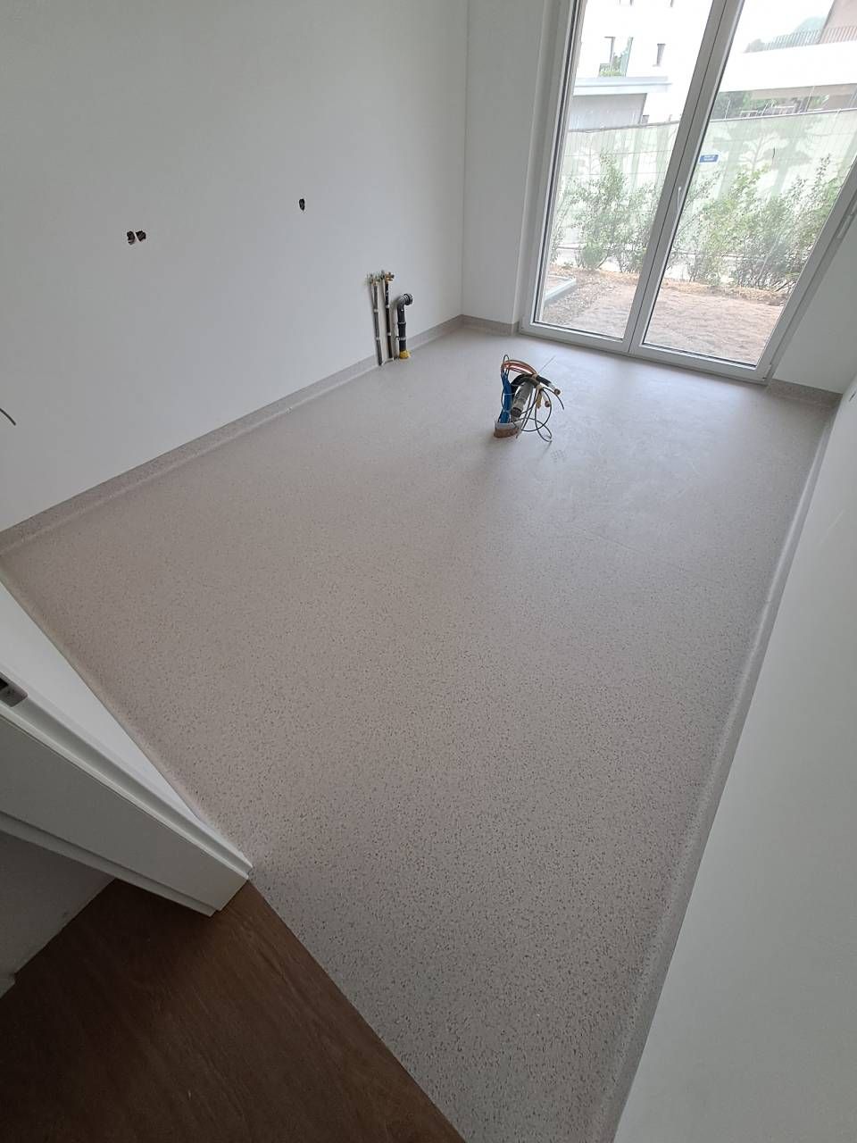 Une pièce avec un sol recouvert de moquette et une fenêtre.