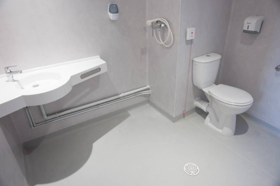 Une salle de bain avec WC, lavabo et douche.