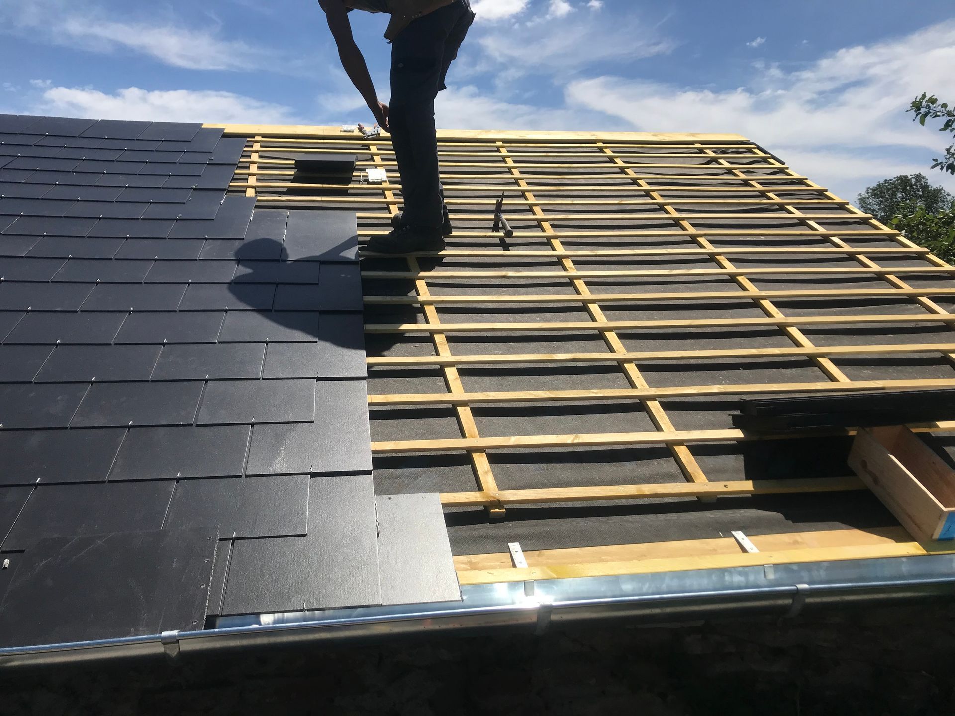 Homme sur un toit pour la pose de couverture