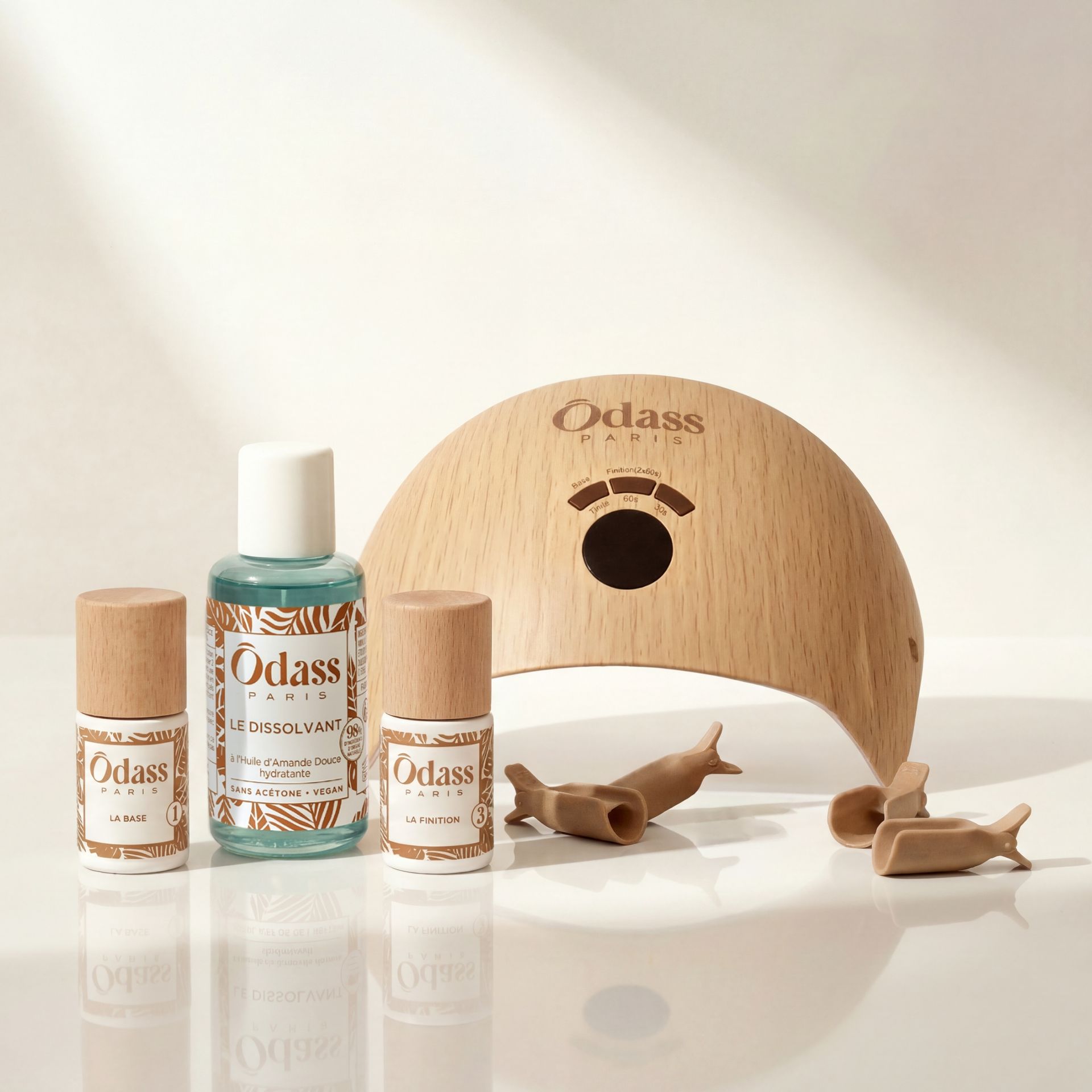 Mains aux longs ongles manucurés avec tons pastel, mer en fond.