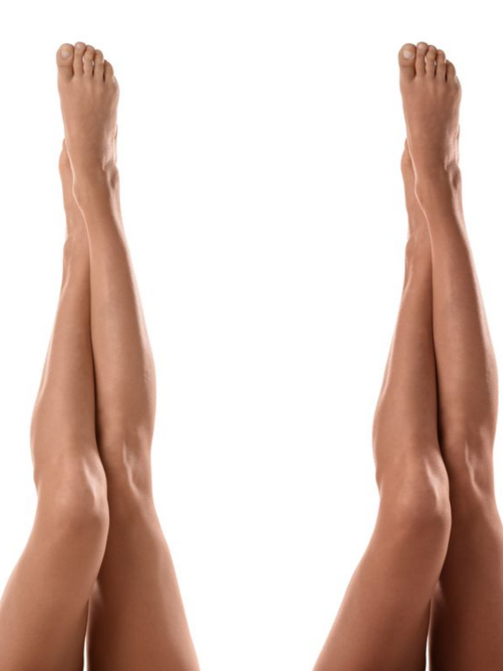Deux paires de jambes levées, pieds joints, sur fond blanc, l'une avec un bronzage plus prononcé.