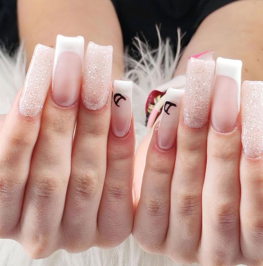 Ongles manucurés et pailletés très longs sur fond de fourrure.