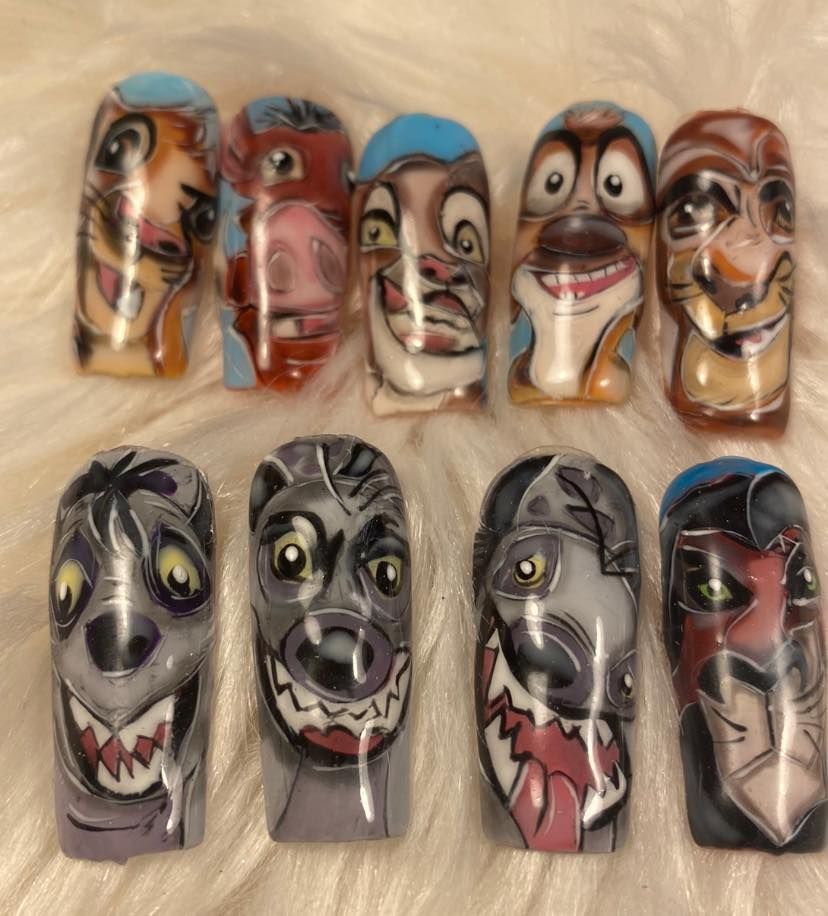 Ongles décorés et peints avec des visages de personnages de dessin animé sur deux rangées.