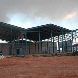 Se está construyendo un gran edificio en medio de un campo de tierra.