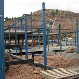 Se está construyendo una gran estructura metálica sobre un campo de tierra.