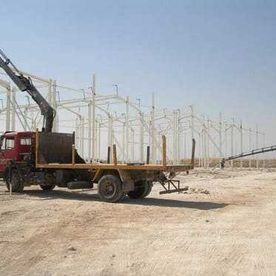 Un camión rojo con una grúa en la parte trasera está estacionado en un campo de tierra.
