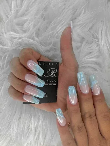 Deux mains aux ongles longs et carrés, ornés d'un dégradé bleu et blanc, tenant une carte de visite noire.