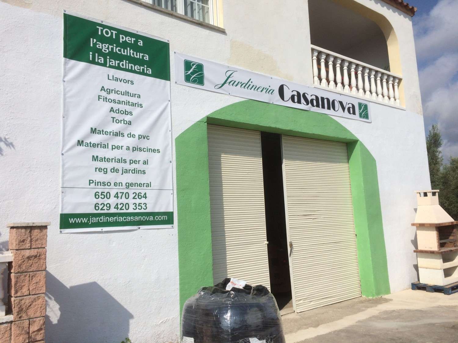 Edificio blanco con puerta verde y letrero de “Casaviva”, además de un tanque de aguas negras en la entrada.