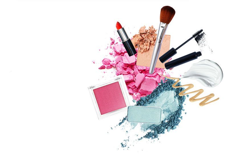 Make-up-Produkte, darunter Lippenstift, Rouge, Lidschatten, Mascara und Pinsel auf weißem Hintergrund.
