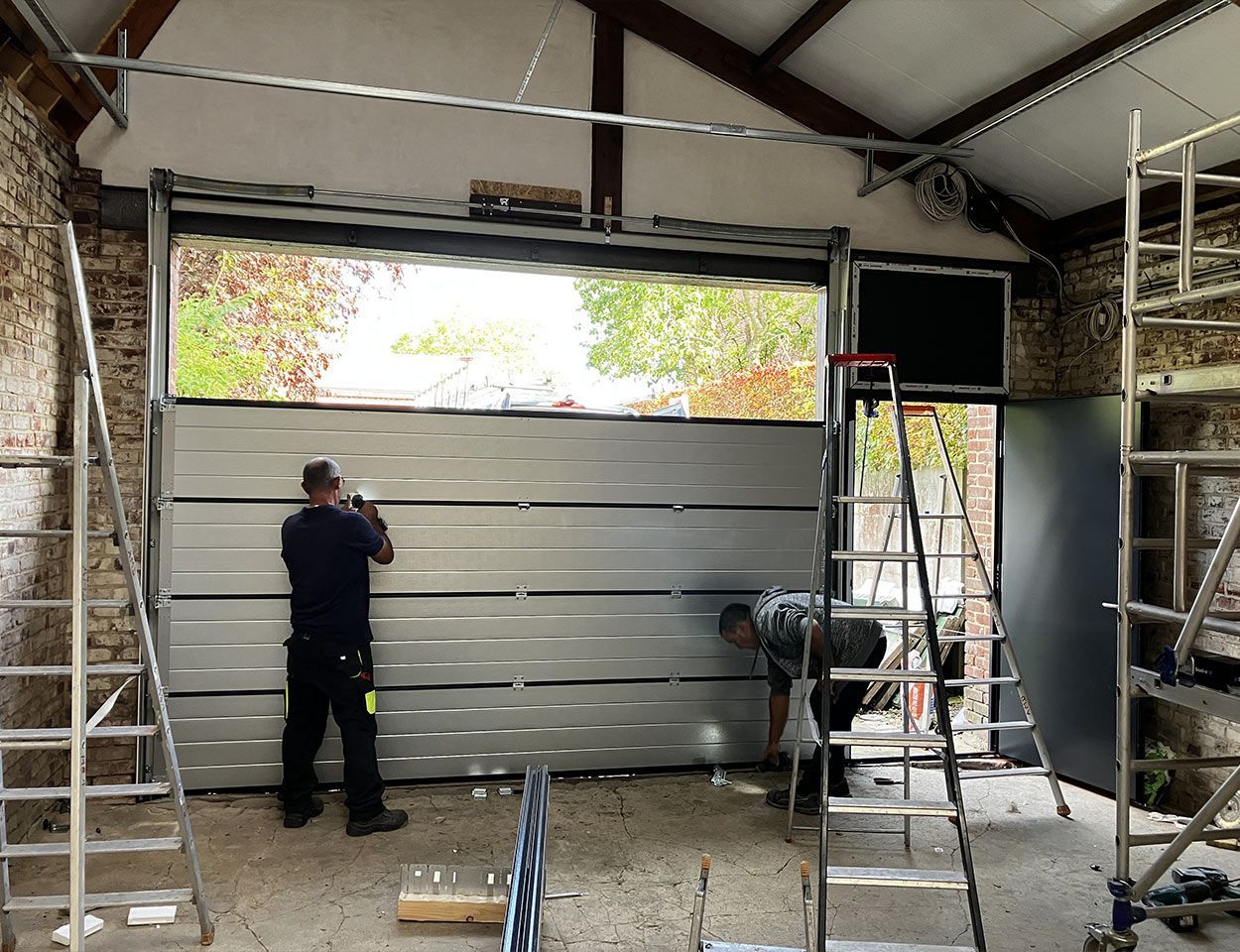 Ouvrier intervenant en urgence sur la réparation d'une porte de garage