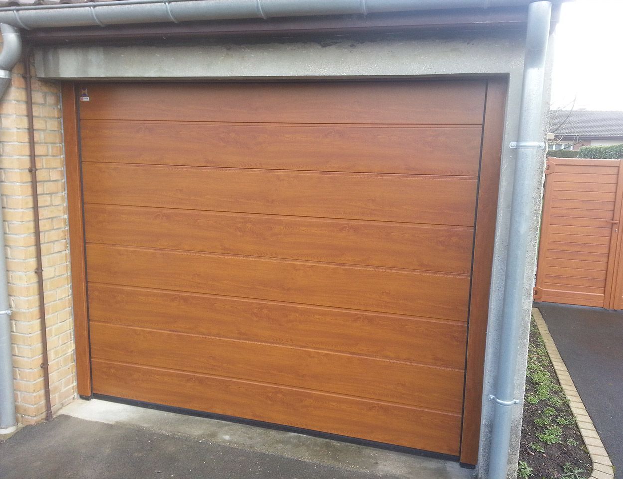 Porte de garage sectionnelle fermée de couleur bois clair