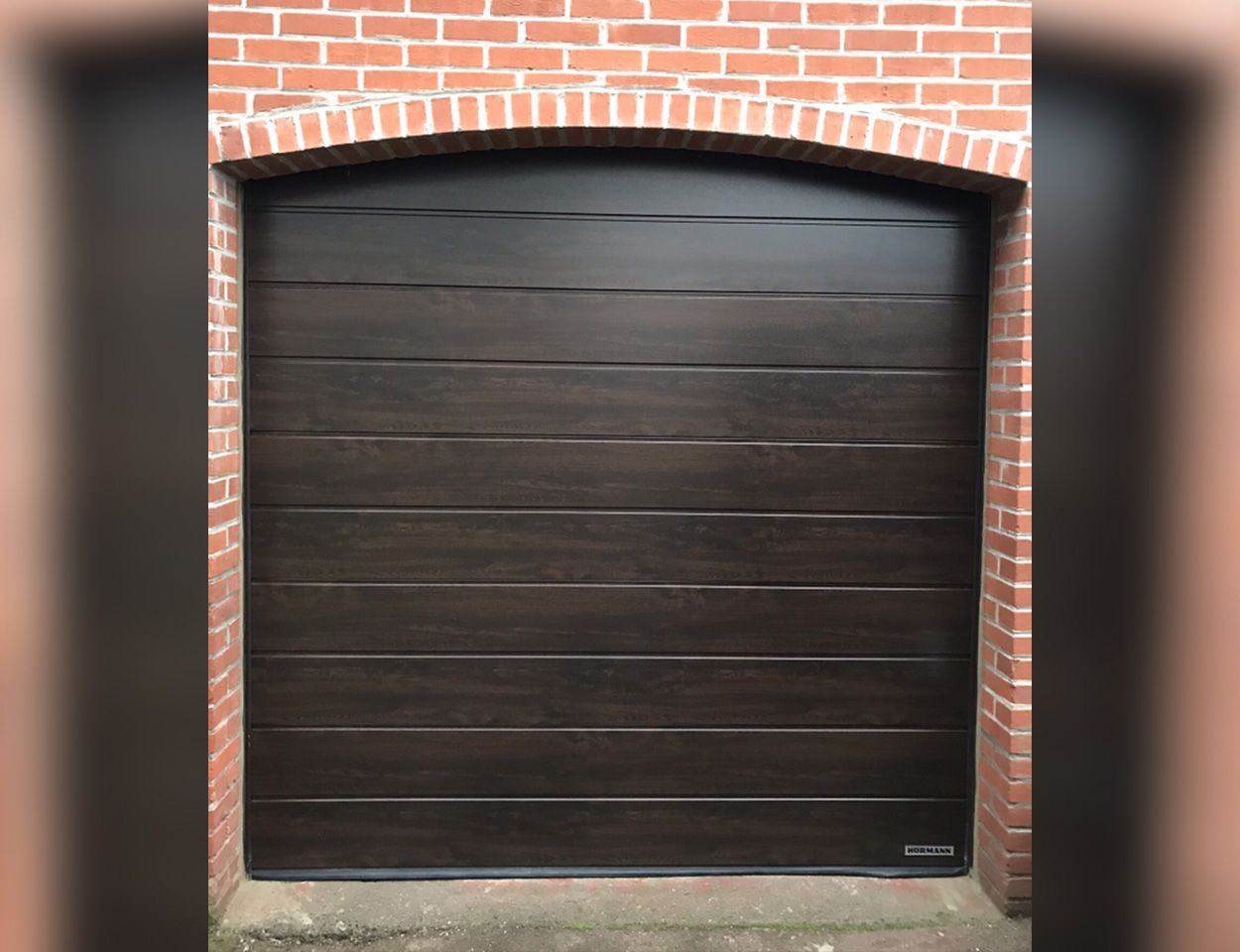 Porte de garage sectionnelle de couleur bois foncé 