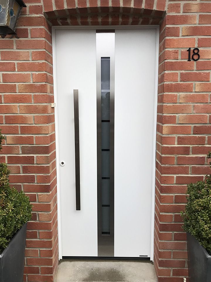 Porte d'entrée de couleur blanche avec une poignée et une petite vitre