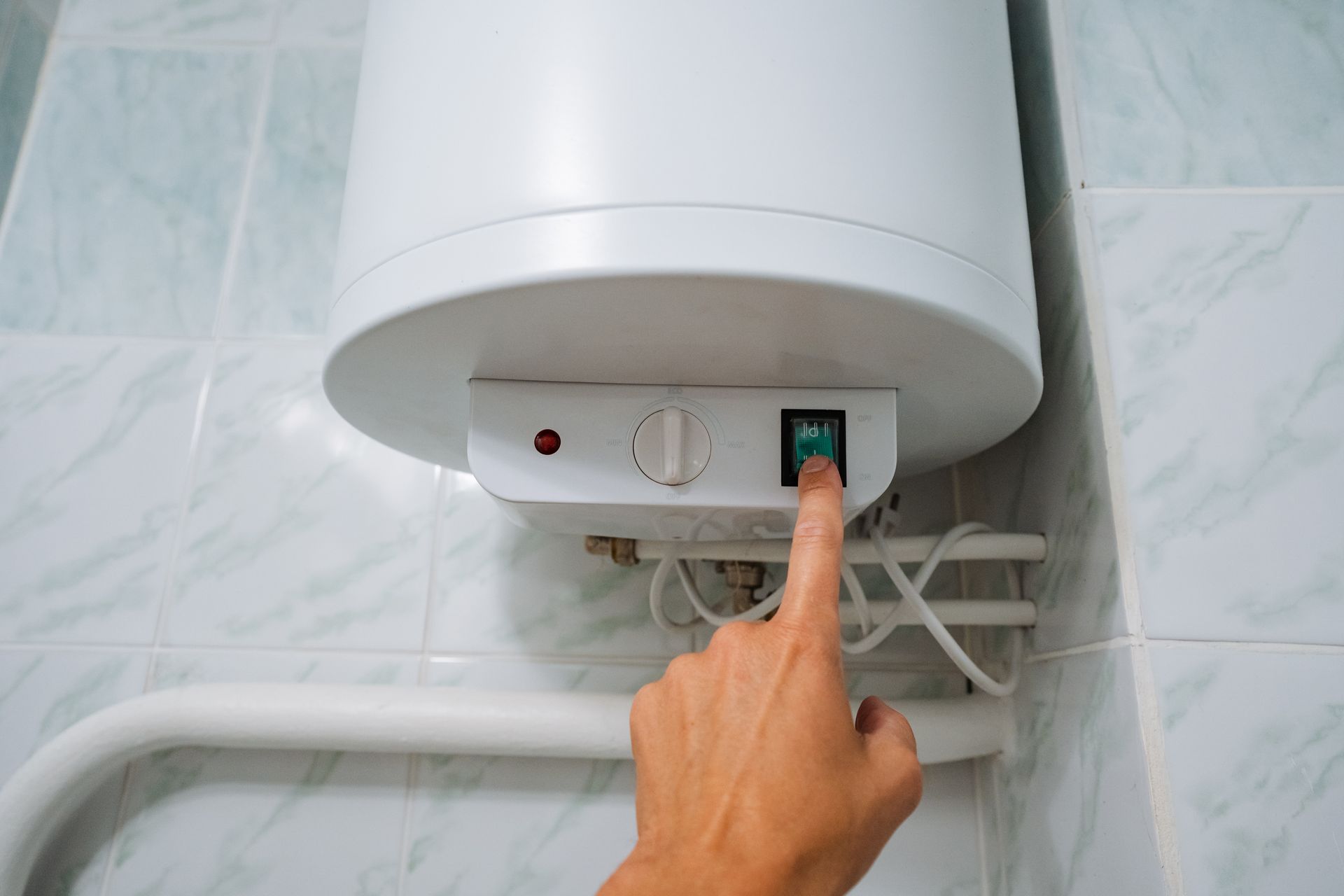 Actionnement manuel d'un interrupteur de chauffe-eau.