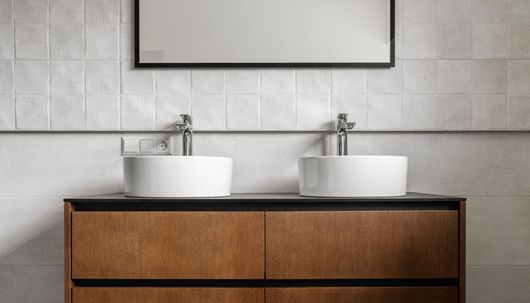Salle de bains moderne avec double vasque sur meuble en bois.
