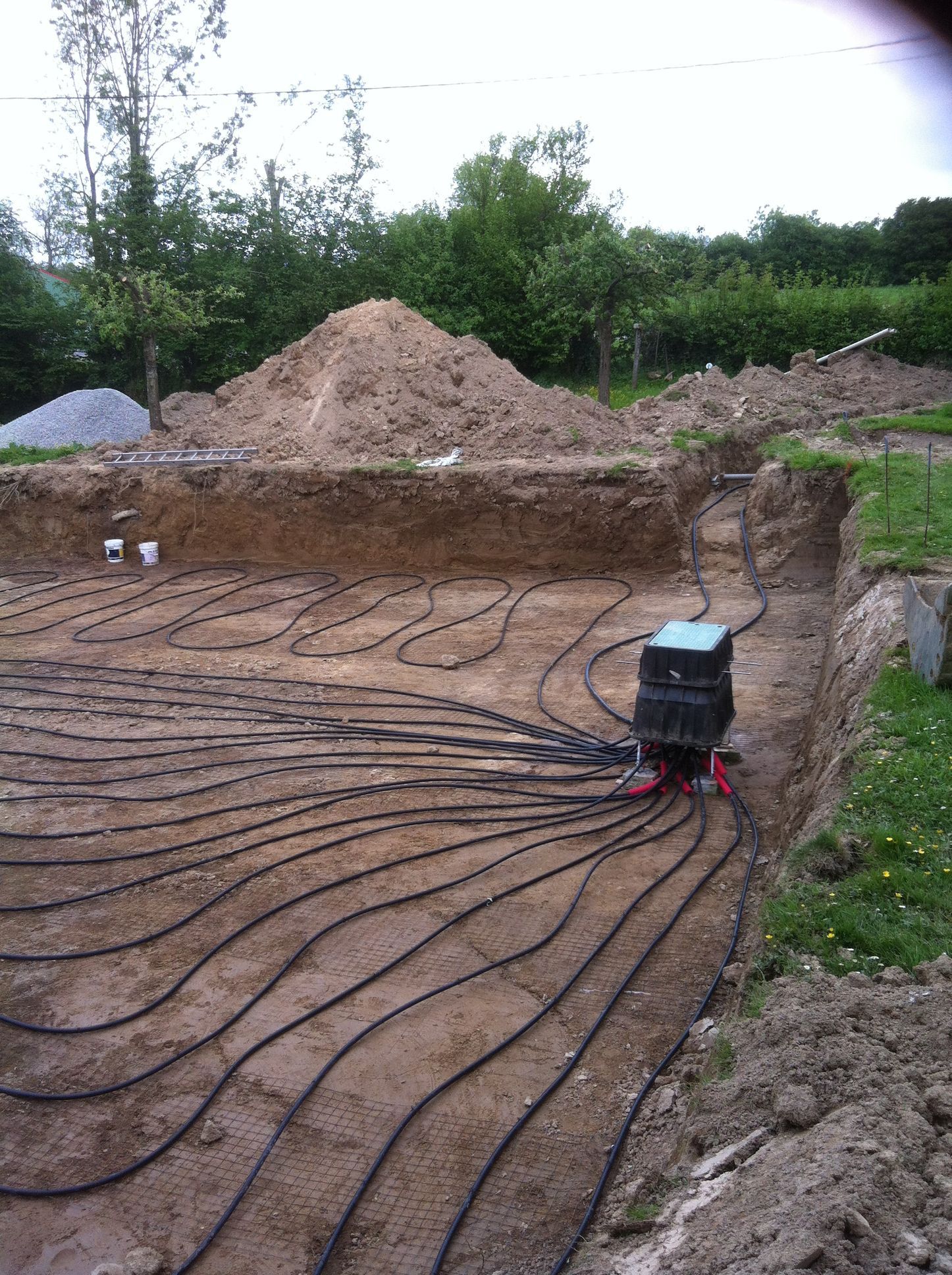 Installation d'un système de chauffage géothermique dans une tranchée.
