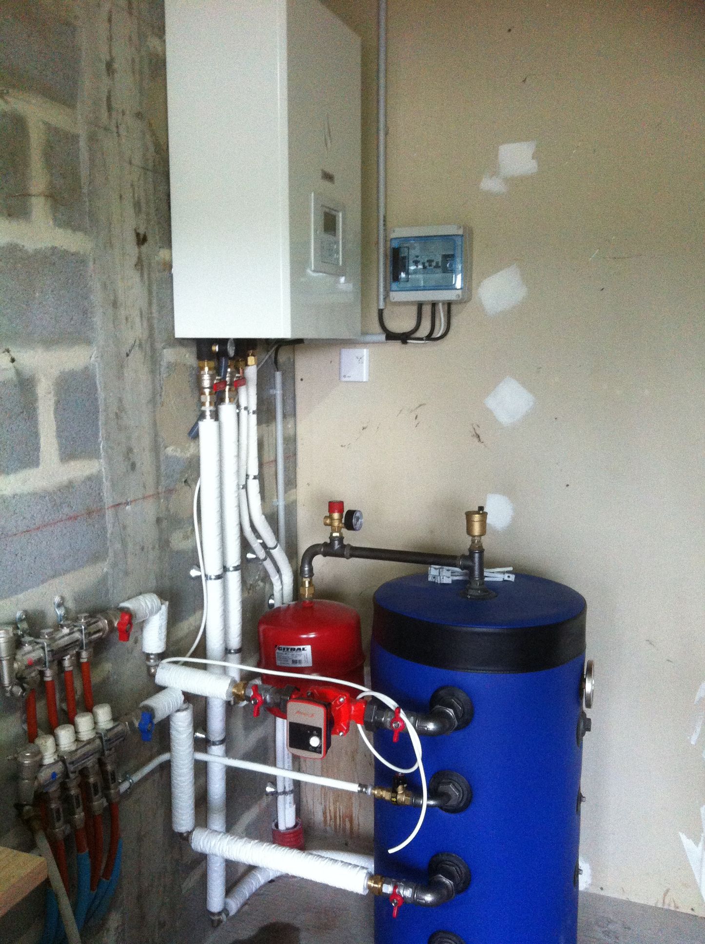 Composants du système de chauffage : chaudière, vase d’expansion, chauffe-eau, tuyaux et panneau de commande.